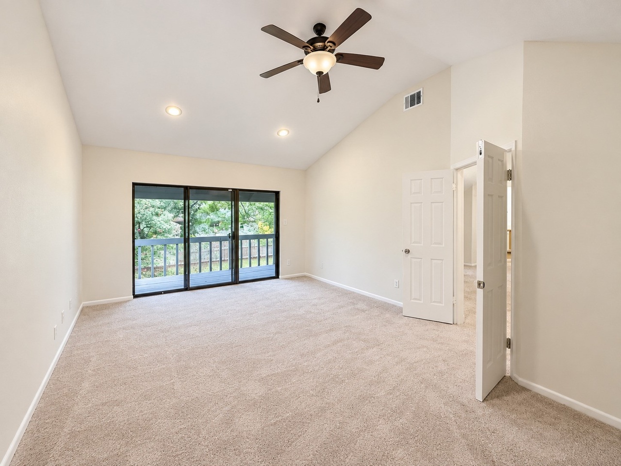 Vaulted primary bedroom with private balcony access